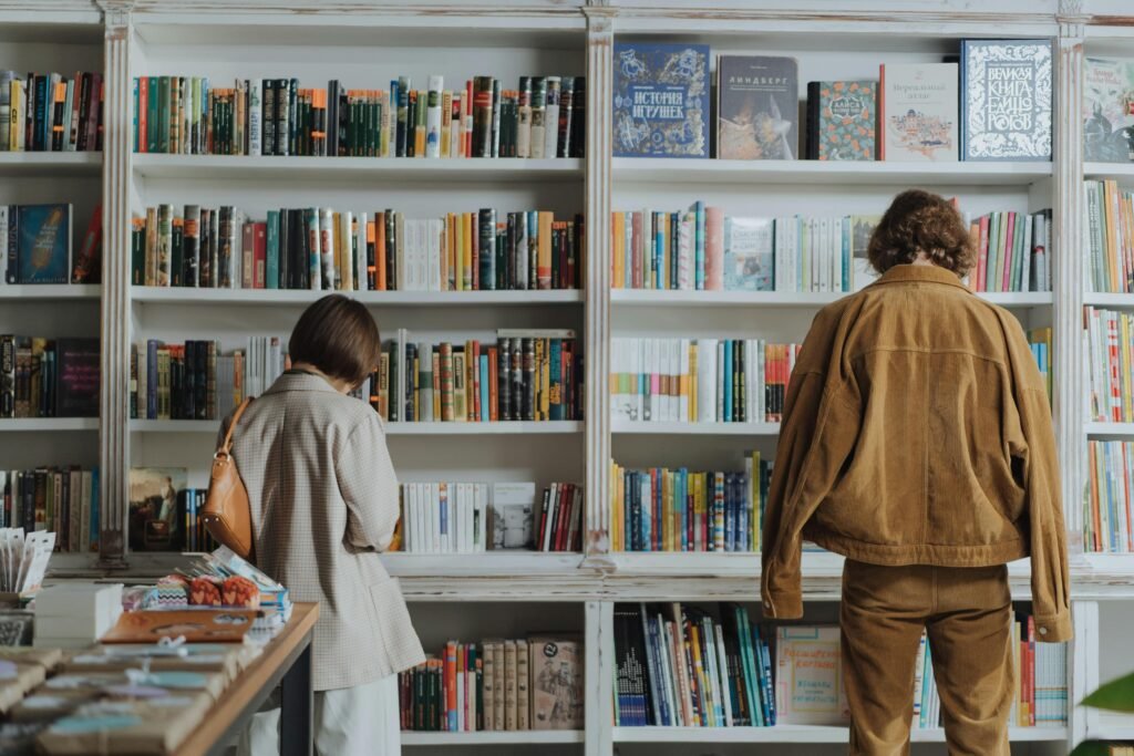 Two adults browsing books in a cozy bookstore, enjoying leisure time and self-education.