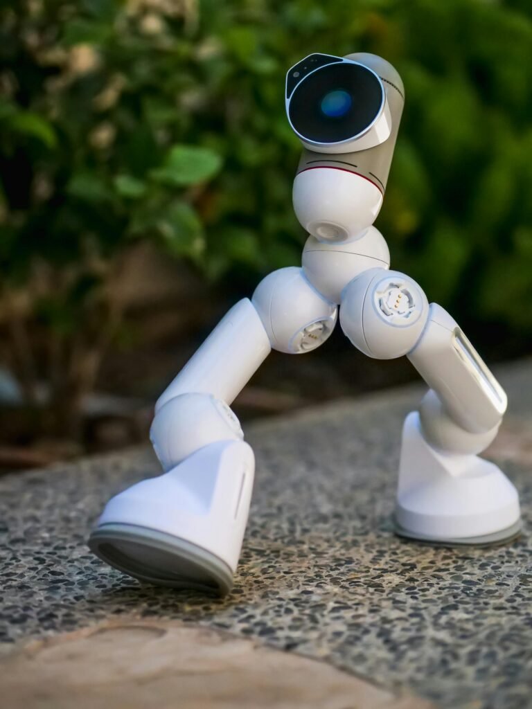 A modern robot with advanced technology walking on an outdoor pebble path.