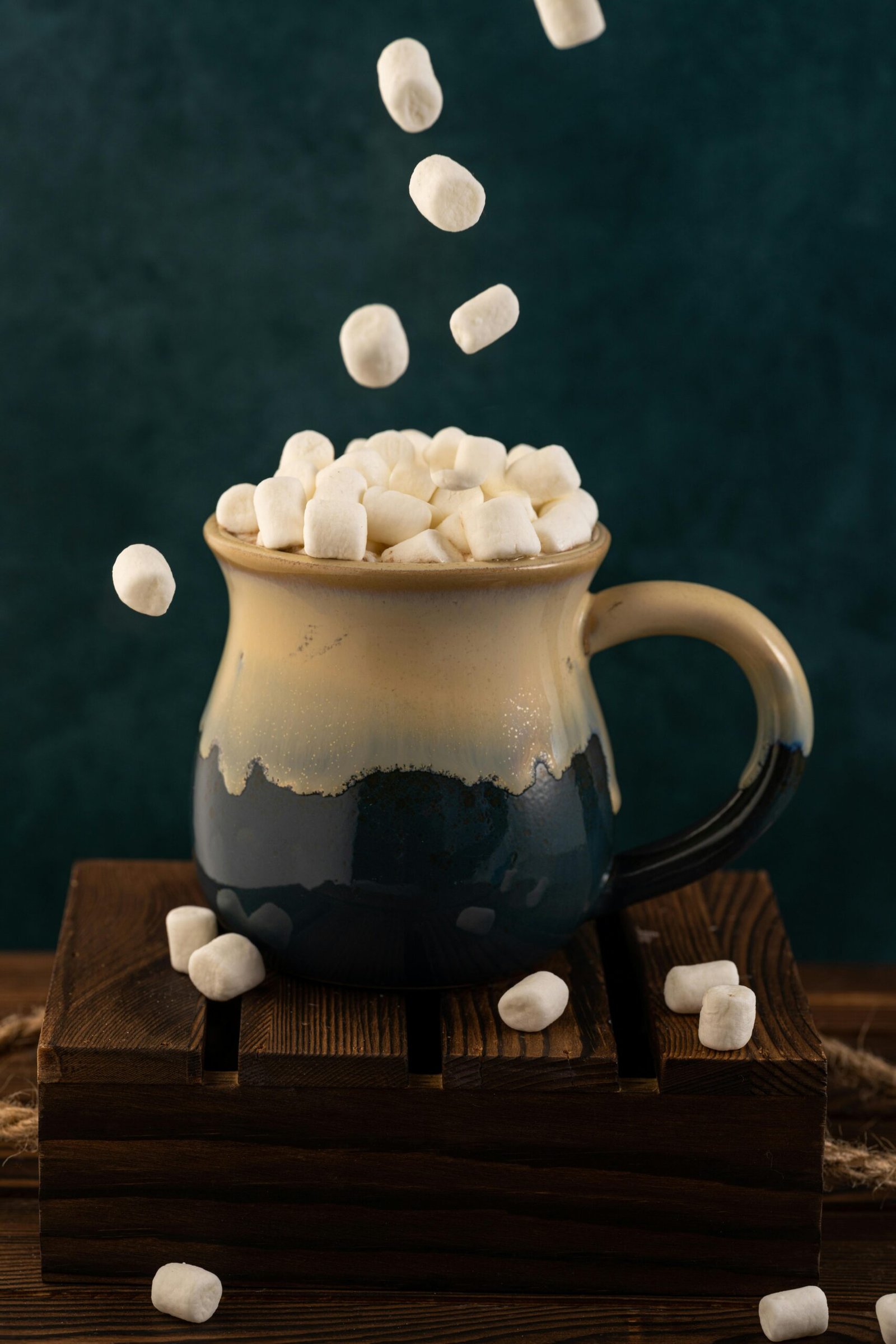 Ceramic mug filled with marshmallows on a wooden surface, perfect for warm, cozy vibes.
